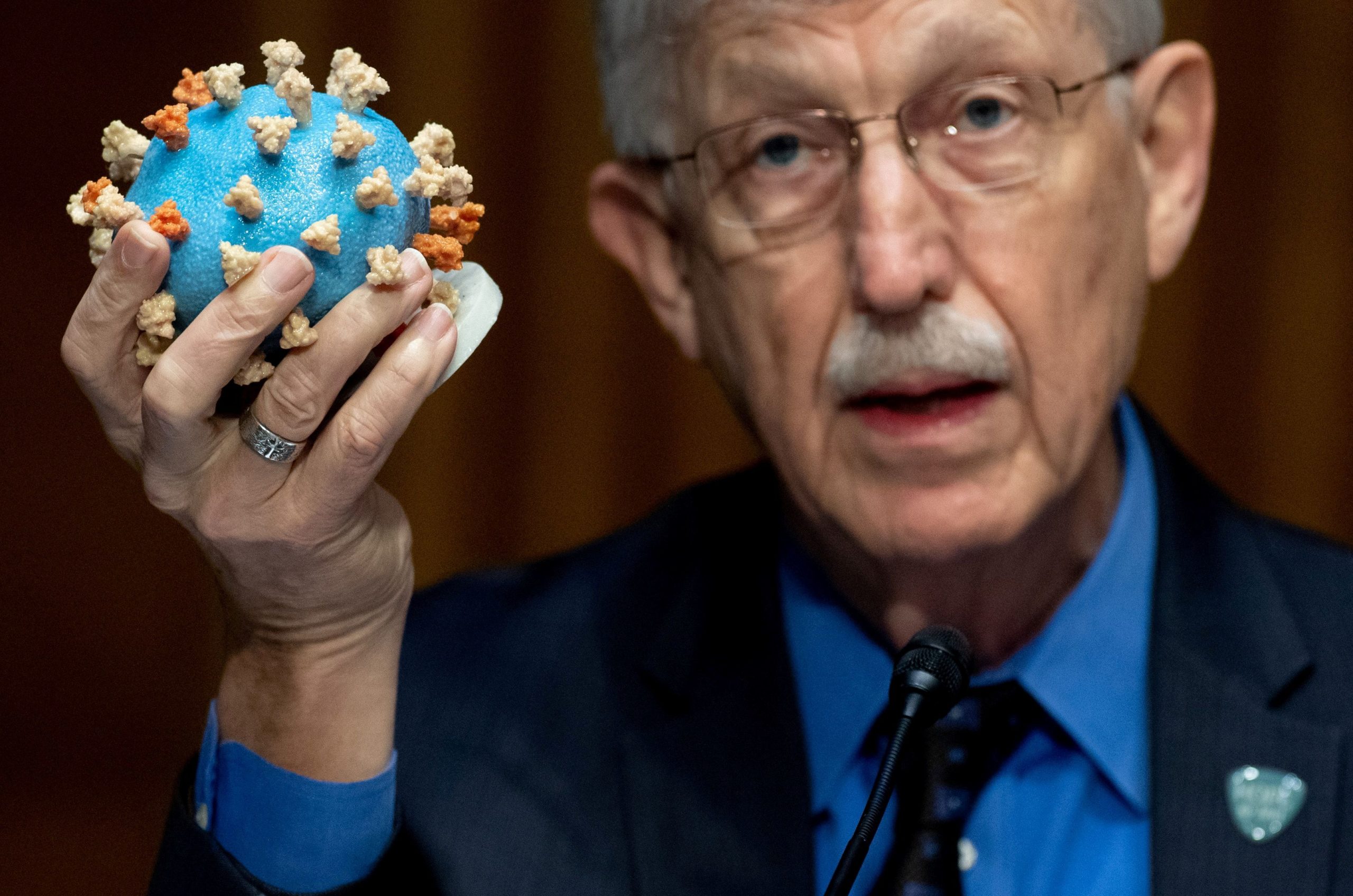 FILE PHOTO: Dr Francis Collins, director of the National Institutes of Health (NIH), holds up a model of SARS-CoV-2, known as the novel coronavirus,  during a U.S. Senate Appropriations Subcommittee Hearing on the plan to research, manufacture and distribute a coronavirus vaccine, known as Operation Warp Speed on Capitol Hill in Washington, D.C, U.S., July 2, 2020. Saul Loeb/Pool via REUTERS/File Photo - RC2BYH9UYBY3
