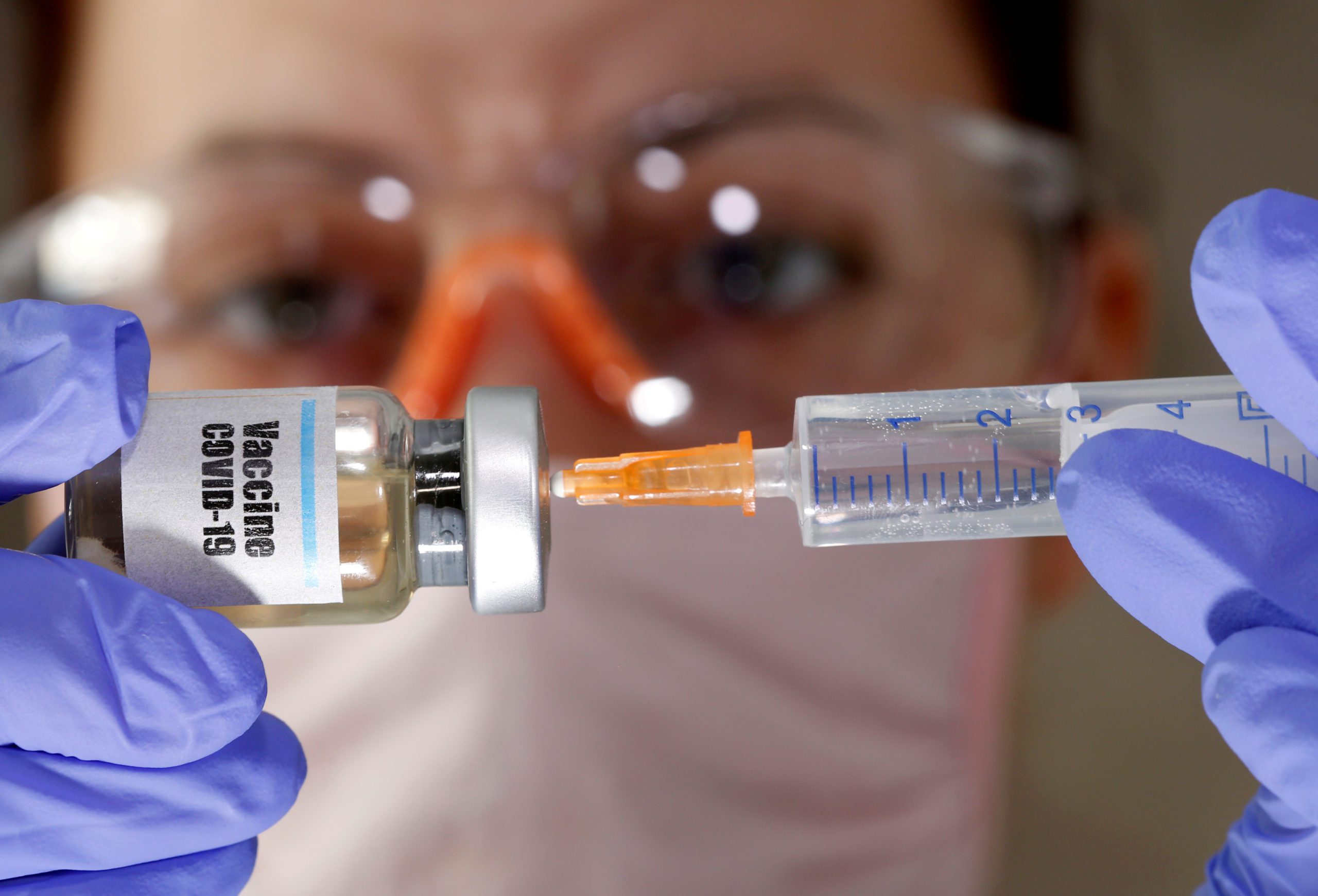 FILE PHOTO: A woman holds a small bottle labeled with a 