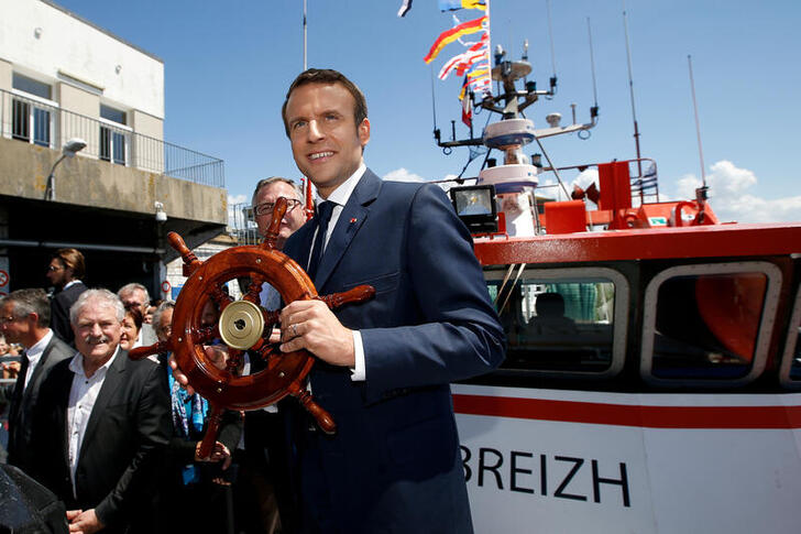 FILE PHOTO: French President Emmanuel Macron receives a gift on a trawler as he visits the harbour of Lorient, France, June 1, 2017. REUTERS/Stephane Mahe/File Photo