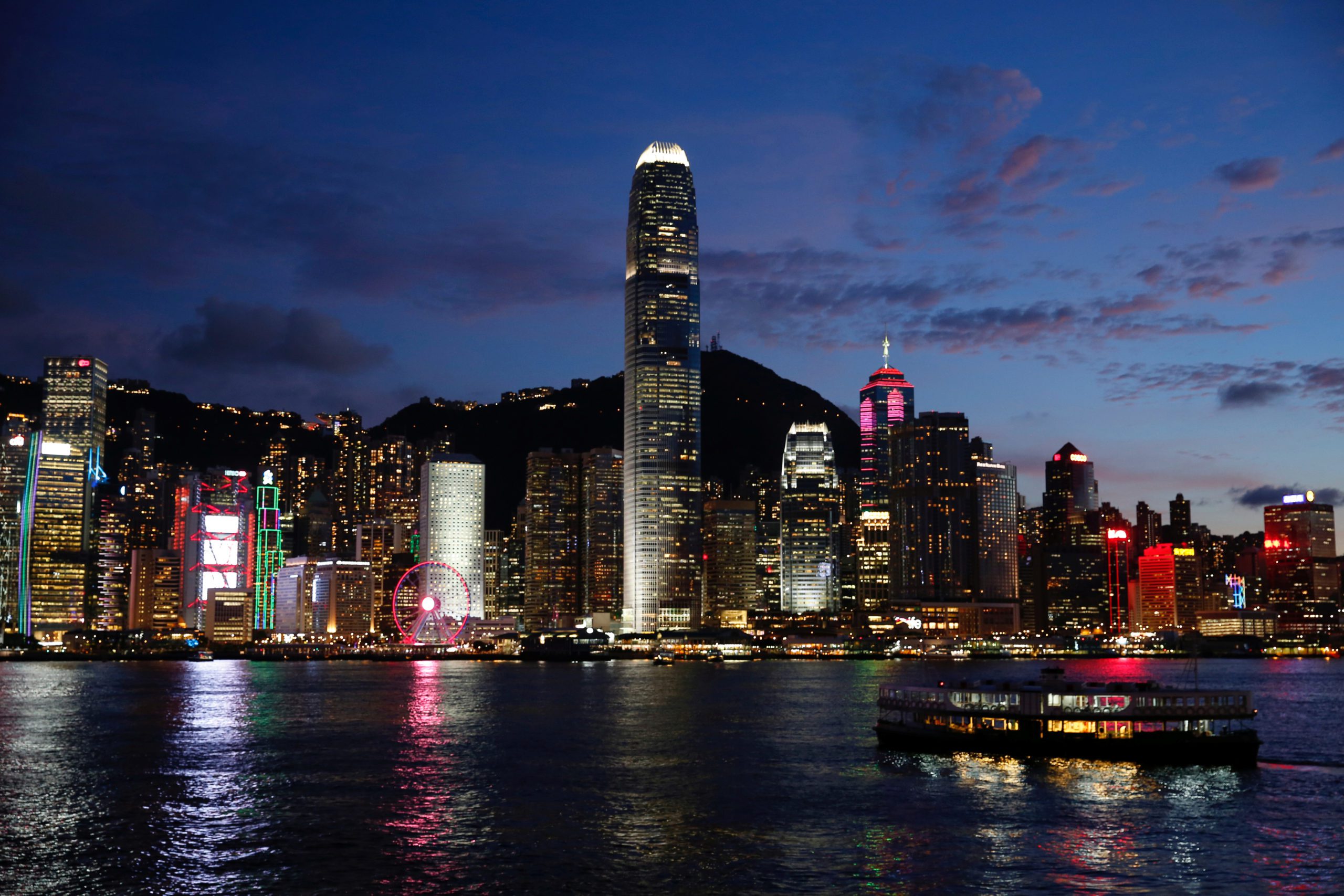 A Star Ferry boat crosses Victoria Harbour in front of a skyline of buildings during sunset, as a meeting on national security legislation takes place in Hong Kong, China June 29, 2020. REUTERS/Tyrone Siu - RC21JH93NO4E