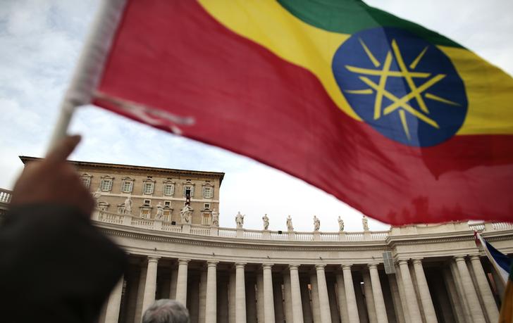 A man waves an Ethiopian flag as Pope Francis leads his Sunday Angelus prayer, on the World day of Migrants and Refugees, in Saint Peter's square at the Vatican January 19, 2014.  REUTERS/Tony Gentile (VATICAN - Tags: RELIGION)