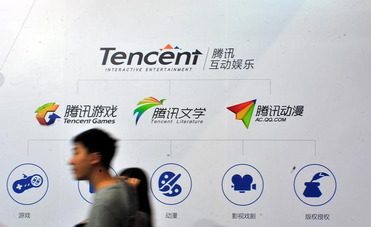 People walk past a logo of Tencent Literature at a Tencent Interactive Entertainment stand during a book fair in Guangzhou, Guangdong province, China August 17, 2014. Picture taken August 17, 2014. REUTERS/Stringer ATTENTION EDITORS - THIS IMAGE WAS PROVIDED BY A THIRD PARTY. CHINA OUT. NO COMMERCIAL OR EDITORIAL SALES IN CHINA.