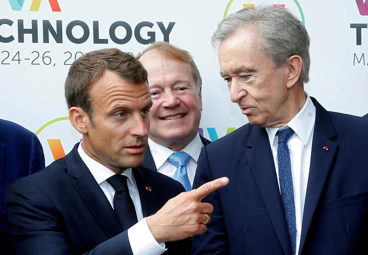 FILE PHOTO: French President Emmanuel Macron talks with LVMH luxury group CEO Bernard Arnault at the Viva Tech start-up and technology gathering in Paris, France, May 24, 2018. Michel Euler/Pool via Reuters/File Photo