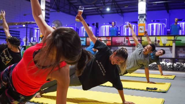 People participate in a beer yoga session at a craft brewery in Phnom Penh