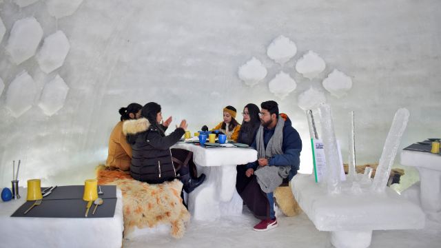 Tourists drink inside “Igloo Cafe” at Gulmarg