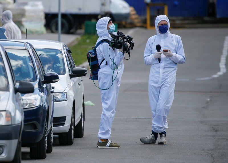 Journalists wearing protective gear wait near a quarantined hostel, which was closed after residents reportedly tested positive for the coronavirus disease (COVID-19), in Kiev, Ukraine April 28, 2020. REUTERS/Gleb Garanich - RC2ODG9E61KZ