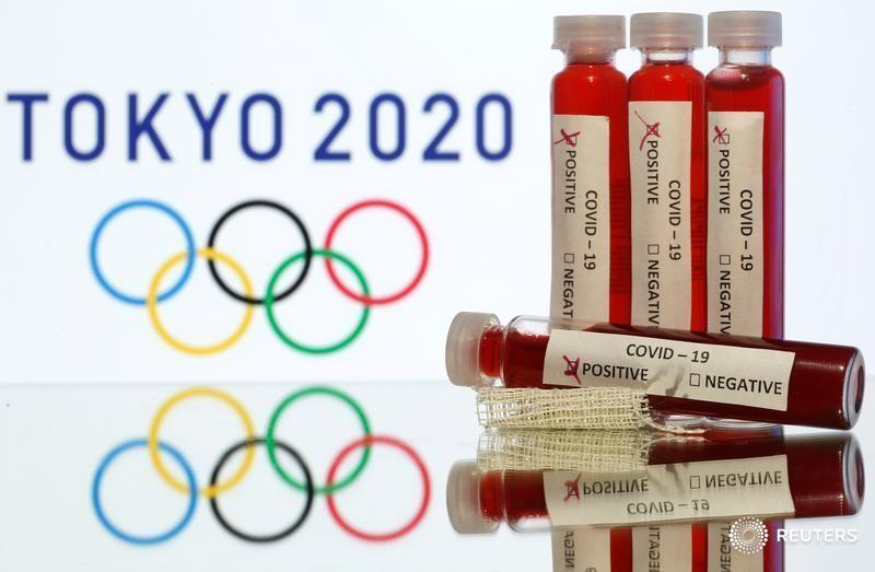 Fake blood in seen in test tubes labelled with coronavirus disease (COVID-19) in front of a displayed Tokyo 2020 Olympics logo in this illustration taken March 19, 2020. REUTERS/Dado Ruvic/Illustration - RC21NF9VNQ46
