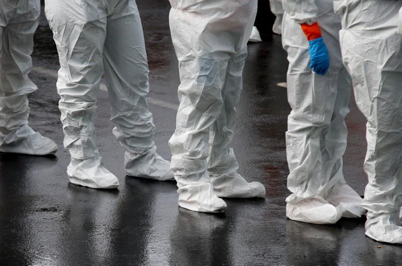 Workers wear protective suits and gloves outside Life Care Center of Kirkland, a long-term care facility linked to several confirmed coronavirus cases, in Kirkland, Washington, U.S., March 12, 2020. REUTERS/Lindsey Wasson - RC2KIF9FVMXD
