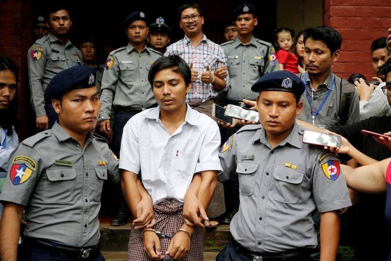 Detained Reuters journalist Kyaw Soe Oo and Wa Lone are escorted by police as they leave after a court hearing in Yangon, Myanmar, August 20, 2018. REUTERS/Ann Wang