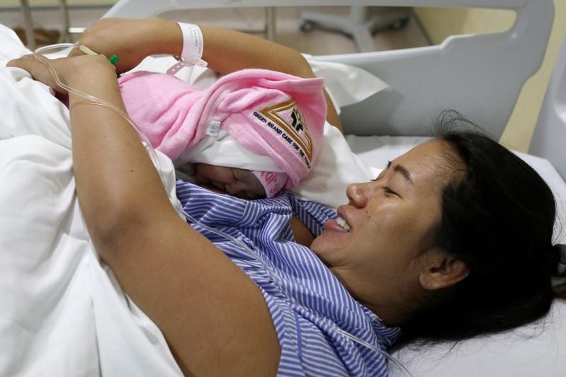 Pan Ei Mon, the wife of detained Reuters journalist Wa Lone, embraces her new born baby girl Thet Htar Angel in her hospital room in Yangon, Myanmar August 10, 2018. REUTERS/Ann Wang