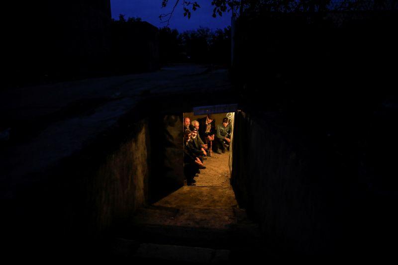 Local residents take shelter in a dugout during the fighting over the breakaway region of Nagorno-Karabakh in the city of Terter, Azerbaijan October 6, 2020. REUTERS/Umit Bektas