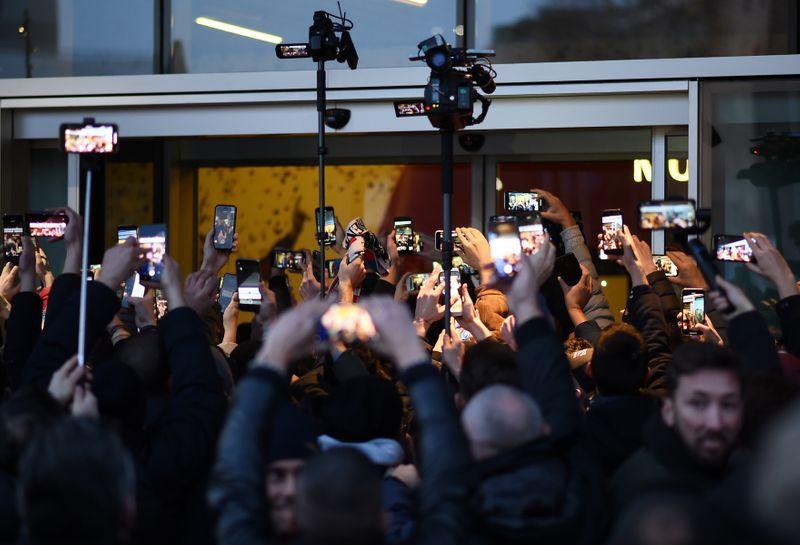 Soccer Football - Zlatan Ibrahimovic in Milan ahead of signing for AC Milan - Milan, Italy - January 2, 2020 AC Milan fans hold up mobile phones with the media outside Casa Milan as they wait to see Zlatan Ibrahimovic ahead of him signing for AC Milan REUTERS/Daniele Mascolo