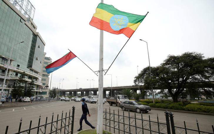 A police officer walks past the flags of Ethiopia and Eritrea ahead of Eritrea's President Isaias Afwerki's visit to Addis Ababa, Ethiopia July 13, 2018. REUTERS/Tiksa Negeri