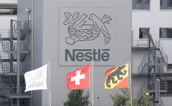 FILE PHOTO: A Swiss national flag flies beside a flag of the canton of Bern in front of the logo of Nestle at a plant in Konolfingen, Switzerland September 28, 2020. REUTERS/Arnd Wiegmann/File Photo