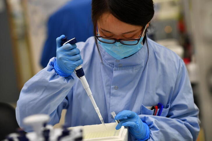 Scientists work at a laboratory where they sequence the novel coronavirus genomes at COVID-19 Genomics UK, on the Wellcome Sanger Institute's 55-acre campus south of Cambridge, Britain March 12, 2021. Picture taken March 12, 2021.  REUTERS/Dylan Martinez