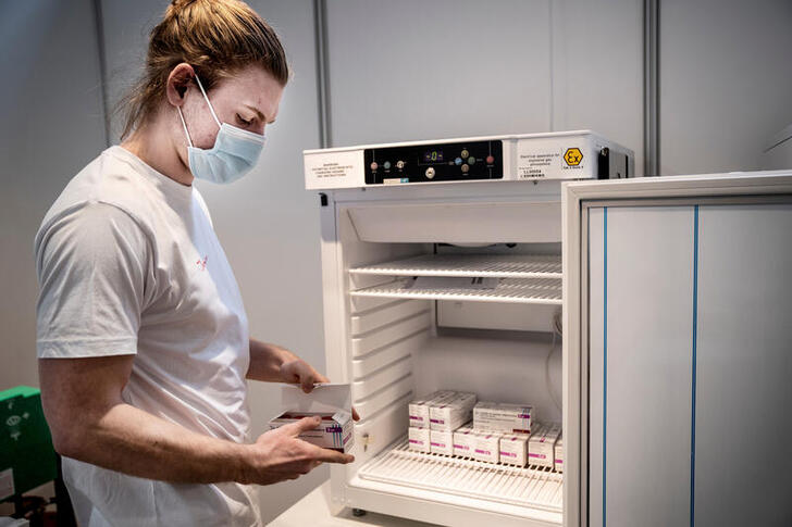 FILE PHOTO: Staff member handles AstraZeneca COVID-19 vaccines in storage at Region Hovedstaden's Vaccine Center, Copenhagen, Denmark February 11, 2021. Ritzau Scanpix/Liselotte Sabroe via REUTERS    THIS IMAGE HAS BEEN SUPPLIED BY A THIRD PARTY./File Photo