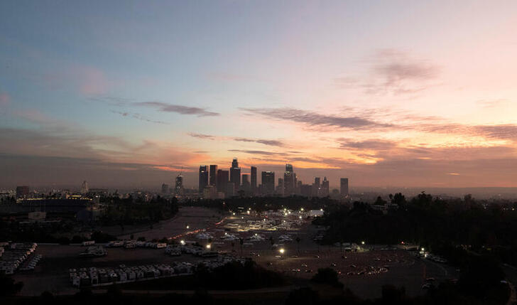FILE PHOTO: Vehicles line up at at Dodger Stadium COVID-19 vaccination site at sunset during the outbreak of the coronavirus disease (COVID-19), in Los Angeles, California, U.S., February 1, 2021. REUTERS/Mario Anzuoni/File Photo
