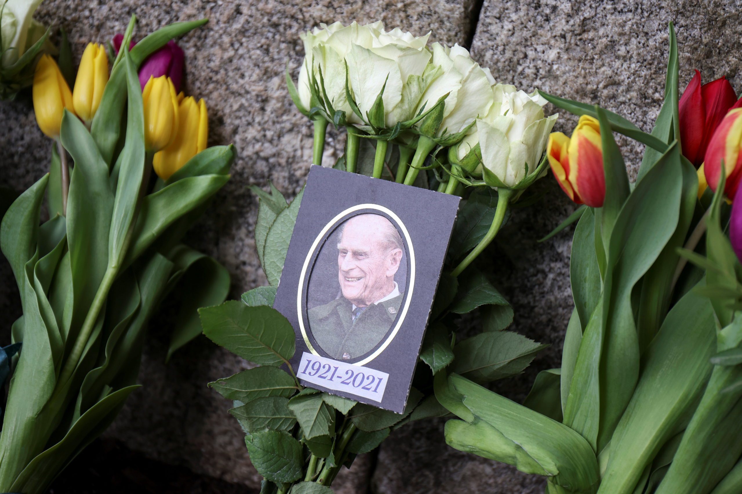 A picture of Britain's Prince Philip, husband of Queen Elizabeth, who died at the age of 99, is seen among the flowers outside Windsor castle, in Windsor, near London, Britain April 14, 2021. REUTERS/Molly Darlington