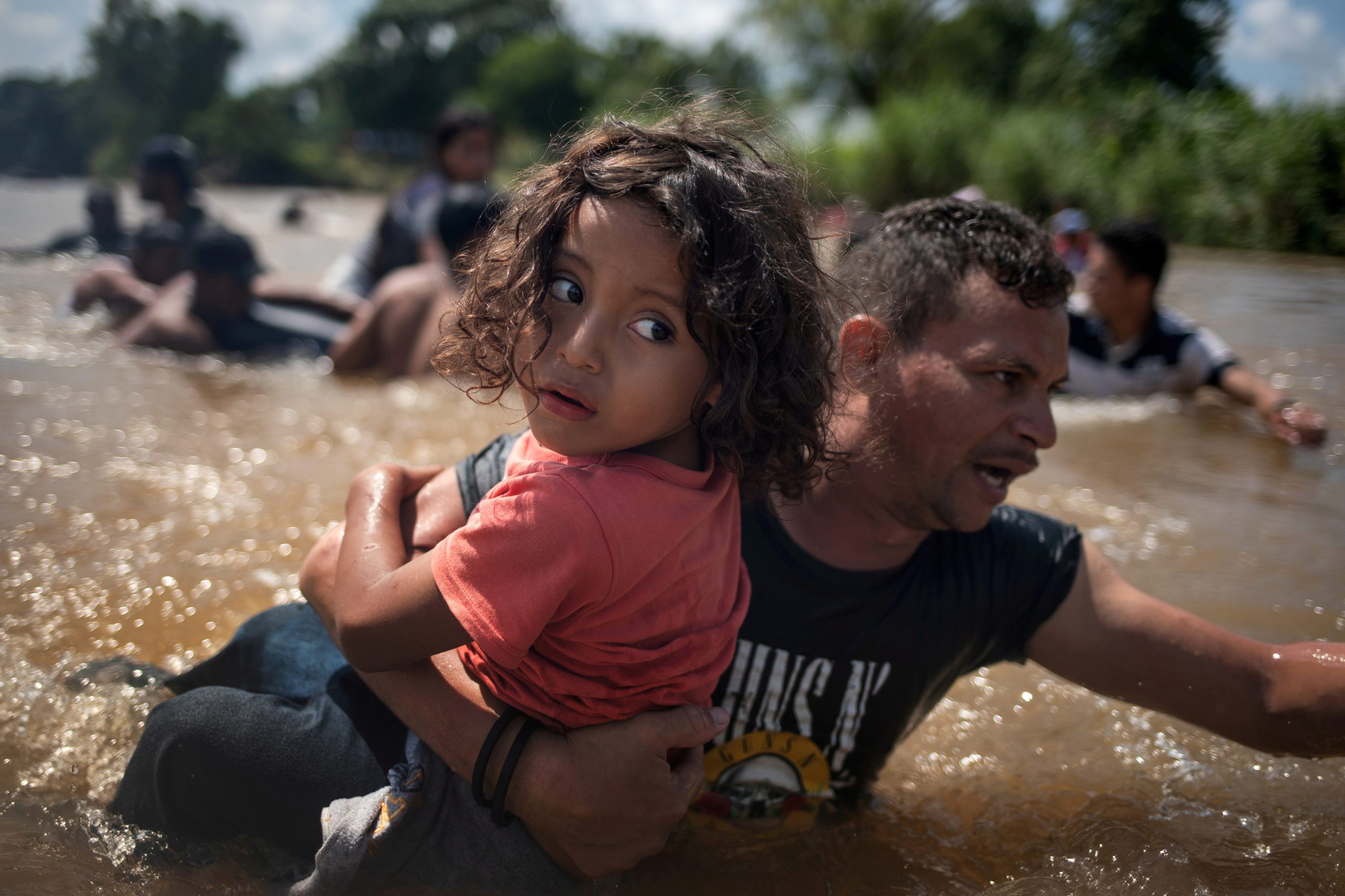 Luis Acosta holds 5-year-old Angel Jesus, both from Honduras, as a caravan of migrants from Central America en route to the United States crossed through the Suchiate River into Mexico from Guatemala in Ciudad Hidalgo, Mexico, October 29, 2018. Picture taken October 29, 2018. REUTERS/Adrees Latif/File Photo   SEARCH 