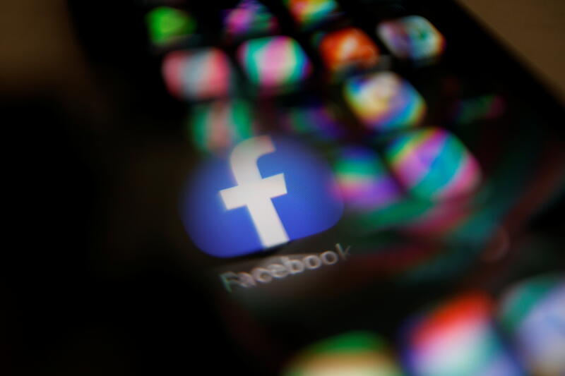 Facebook logo displayed on a mobile phone is seen through a magnifying glass in this picture illustration taken  February 9, 2021. REUTERS/Carlos Jasso - RC28PL9BBXRH