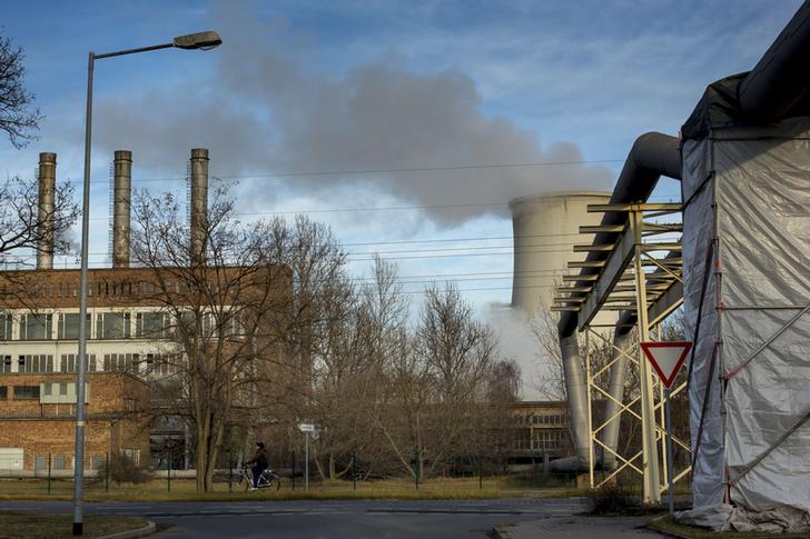 A woman cycles past a power station that is attached to the ArcelorMittal steel factory in Eisenhuettenstadt, 124 km (77 miles) east of Berlin November 26, 2012. Angela Merkel hopes for re-election next year as a reward for keeping the euro zone intact, but many people in the former East Germany where she grew up feel more like second-class citizens than good Europeans and may give her the cold shoulder. Income and jobs in the former German Democratic Republic still lag behind the west more than 20 years after reunification and trillions of euros in transfers have not stemmed an exodus that has left some areas looking like ghost towns. Picture taken November 26, 2012. TO GO WITH STORY GERMANY-EAST/ REUTERS/Thomas Peter (GERMANY  - Tags: POLITICS CITYSPACE SOCIETY)