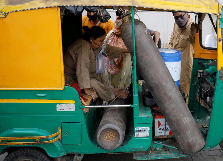 Aminbanu Memon wearing an oxygen mask sits in an autorickshaw waiting to enter a COVID-19 hospital for treatment, amidst the spread of the coronavirus disease (COVID-19) in Ahmedabad, India, April 28, 2021. REUTERS/Amit Dave