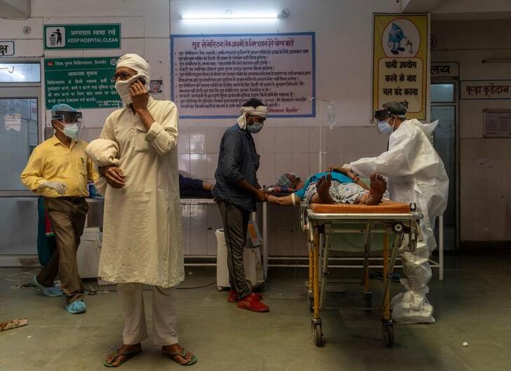 A man speaks on the phone as a doctor tries to revive his wife inside an emergency ward of a government-run hospital, amidst the coronavirus disease (COVID-19) pandemic, in Bijnor district, Uttar Pradesh, India, May 11, 2021. REUTERS/Danish Siddiqui