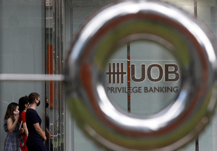 People wearing protective face masks pass a UOB bank branch in Singapore's central business district, during the coronavirus disease (COVID-19) outbreak in Singapore, August 17, 2020.   REUTERS/Edgar Su