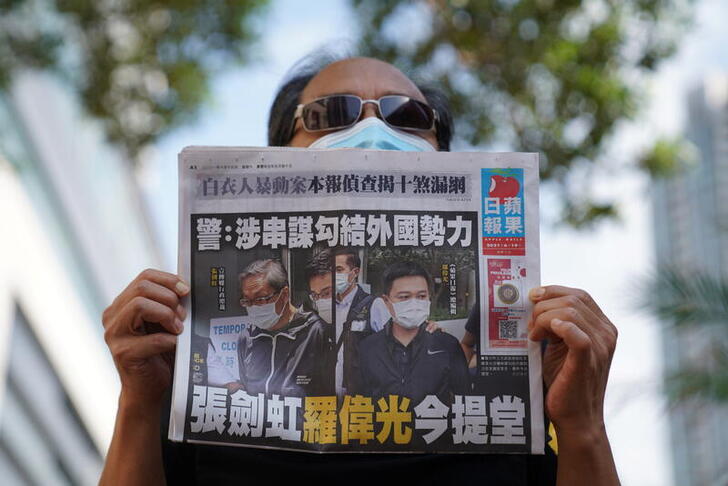 A supporter holds a copy of Apple Daily newspaper during a court hearing outside West Magistrates’ Courts, after police charge two executives of the pro-democracy Apple Daily newspaper over the national security law, in Hong Kong, China, June 19, 2021. REUTERS/Lam Yik