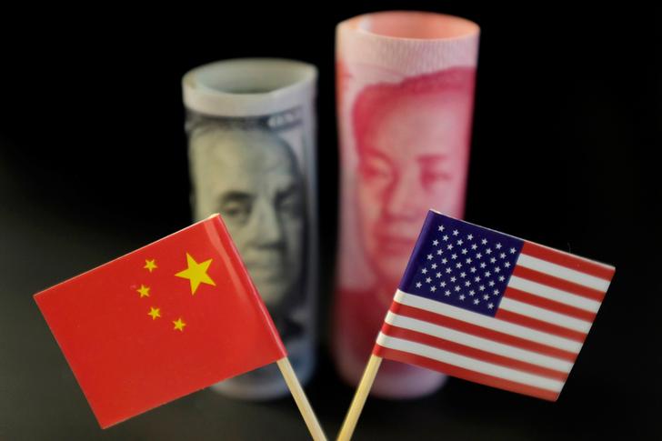 U.S. and Chinese flags are seen in front of a U.S. dollar banknote featuring American founding father Benjamin Franklin and a China's yuan banknote featuring late Chinese chairman Mao Zedong in this illustration picture taken May 20, 2019. Picture taken May 20, 2019. REUTERS/Jason Lee/Illustration