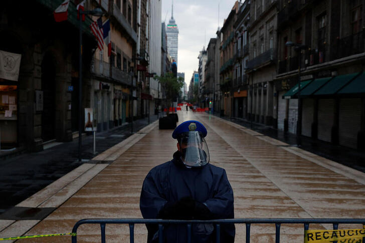 A police officer guards a closed road at the city center after amenities and businesses were shut for the second time this weekend due to overcrowding over the last few days, as the coronavirus disease (COVID-19) outbreak continues, in Mexico City, Mexico July 4, 2020. REUTERS/Carlos Jasso