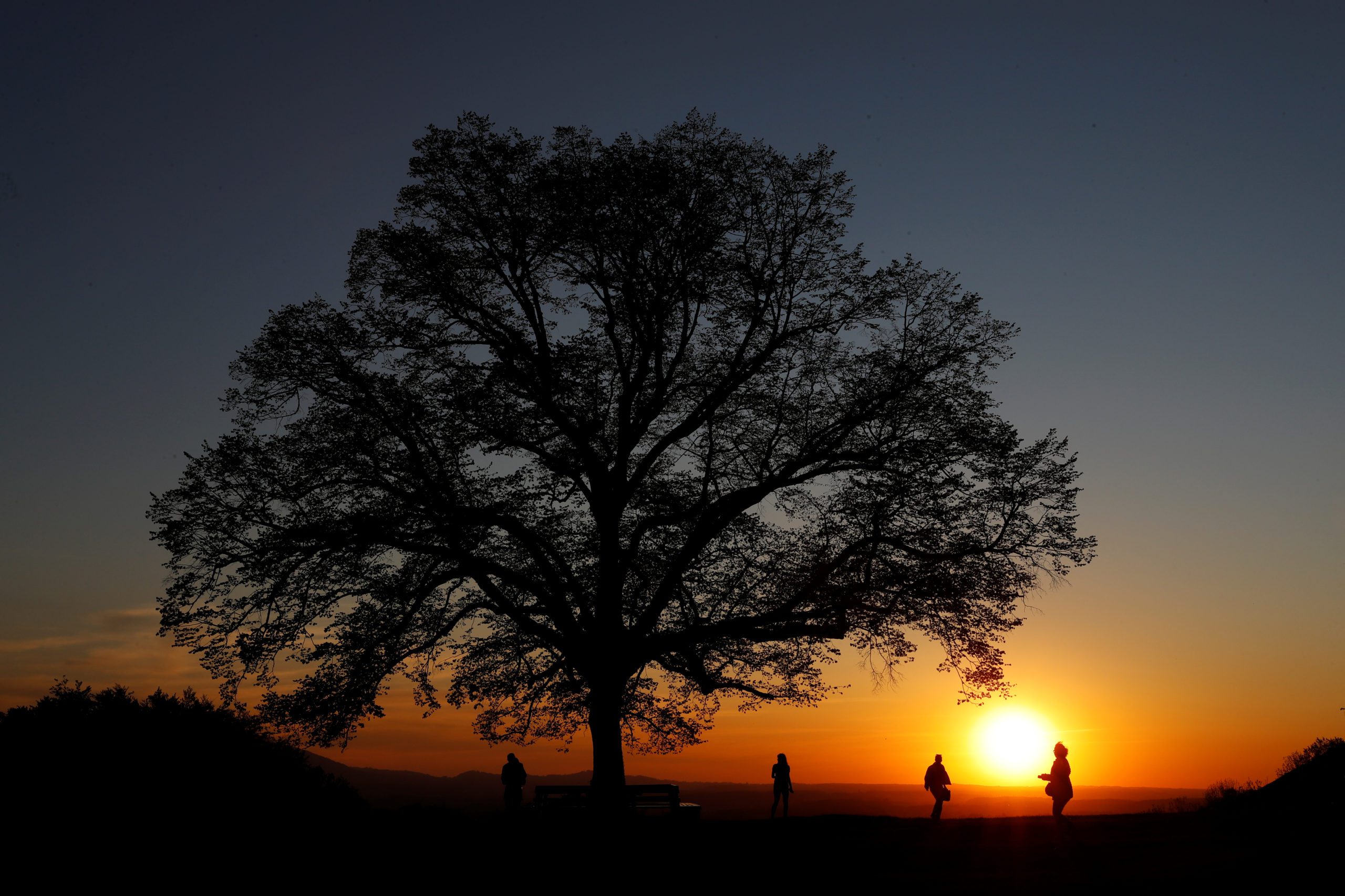 People practise social distancing during sunset after the Austrian government loosened its lockdown restrictions during the coronavirus disease (COVID-19) outbreak in Maria Plain, Austria, April 21, 2020.    REUTERS/Leonhard Foeger - RC279G90JIOH