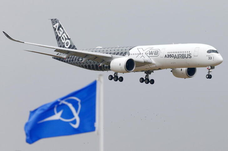 FILE PHOTO: An Airbus A350 jetliner flies over Boeing flags as it lands after a flying display during the 51st Paris Air Show at Le Bourget airport near Paris, June 15, 2015. REUTERS/Pascal Rossignol/File Photo