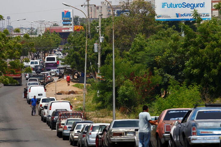 FILE PHOTO: People with vehicles wait in line in an attempt to refuel at a gas station of the state oil company PDVSA in Maracaibo, Venezuela, May 17, 2019. REUTERS/Isaac Urrutia/File Photo/File Photo