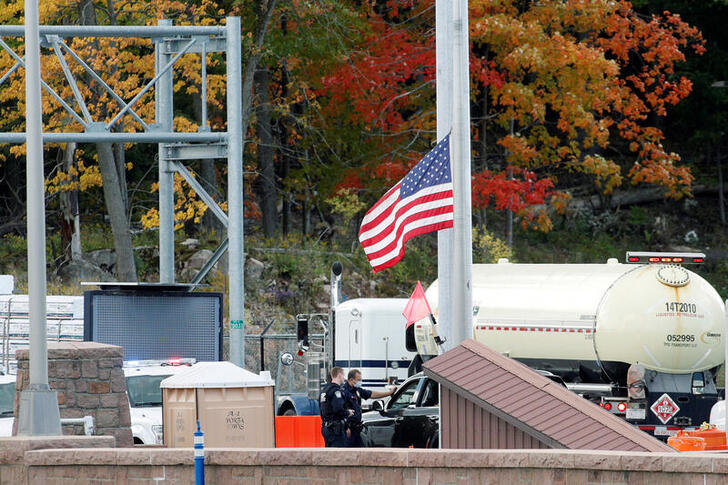 U.S. customs officers speak with a person at the Canada-United States border crossing at the Thousand Islands Bridge, which remains closed to non-essential traffic to combat the spread of the coronavirus disease (COVID-19) in Lansdowne, Ontario, Canada September 28, 2020.  REUTERS/Lars Hagberg