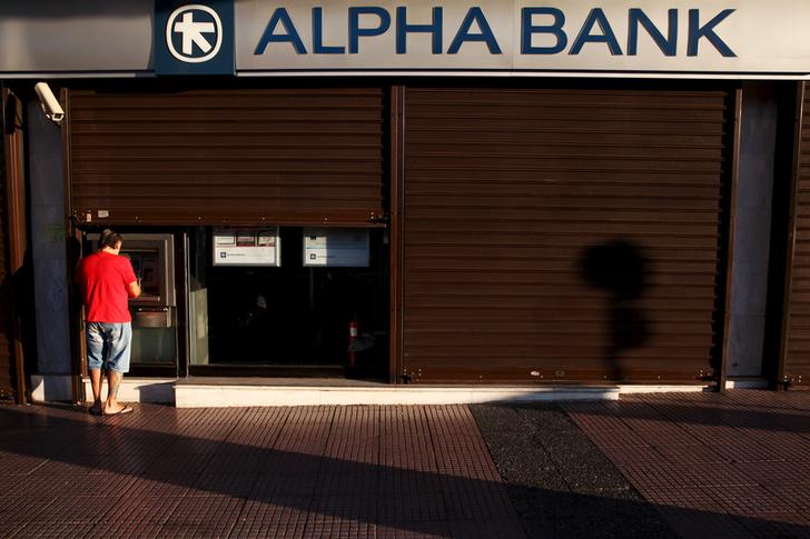 A man withdraws money at an Alpha Bank branch ATM in central Athens, Greece, July 19, 2015. The Greek government ordered banks to open on Monday, three weeks after they were shut down to prevent the system collapsing under a flood of withdrawals, as Prime Minister Alexis Tsipras looked to the start of new bailout talks next week. REUTERS/Yiannis Kourtoglou
