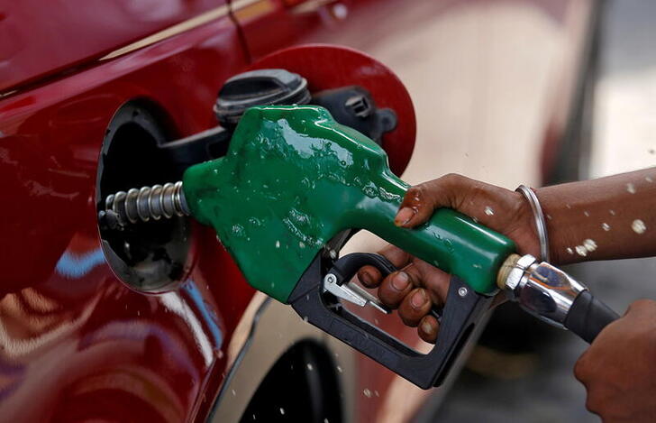 FILE PHOTO: A worker holds a nozzle to pump petrol into a vehicle at a fuel station in Mumbai, India, May 21, 2018. REUTERS/Francis Mascarenhas/File Photo