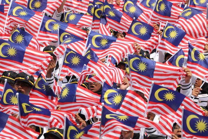 Performers hold up flags during the 62nd Merdeka Day (Independence Day) celebrations in Putrajaya, Malaysia, August 31, 2019.ÊREUTERS/Lim Huey Teng