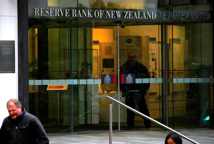 Pedestrians walk past as a security guard stands in the main entrance to the Reserve Bank of New Zealand located in central Wellington, New Zealand, July 3, 2017. Picture taken July 3, 2017.   REUTERS/David Gray