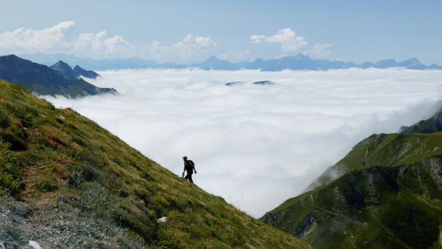 A hiker walks up to the Moleson summit during a cloud inversion in Gruyeres