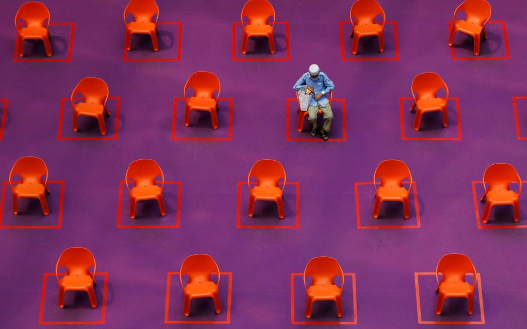 A man sits amongst empty seats at a free movie screening as restrictions on social gathering are tightened in Singapore