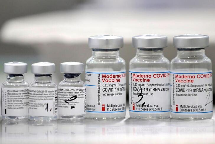 FILE PHOTO: Vials of coronavirus disease (COVID-19) vaccines of Pfizer-BioNTech and Moderna are seen in the town of Ricany near Prague, Czech Republic, February 25, 2021.  REUTERS/David W Cerny/File Photo