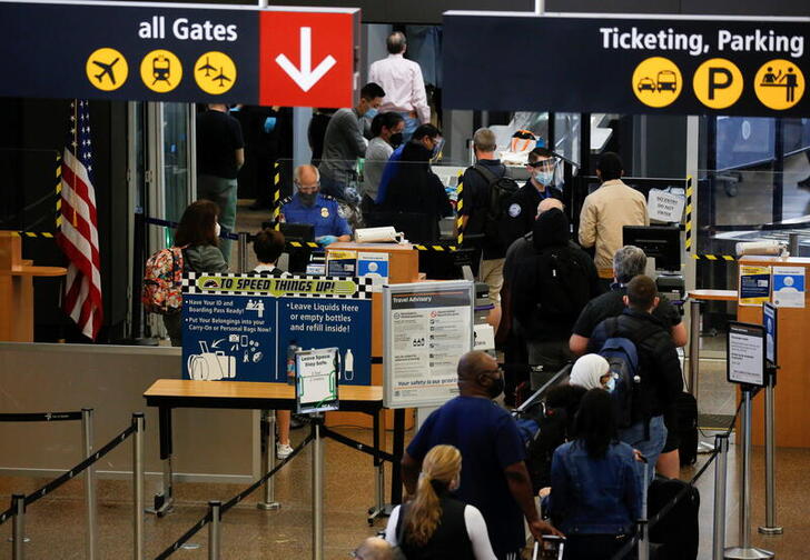 Travelers queue in a security line limited to every other lane for social distancing at Seattle-Tacoma International Airport in SeaTac, Washington, U.S. April 12, 2021.  REUTERS/Lindsey Wasson