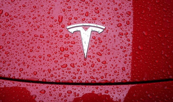 A Tesla logo is pictured on a car in the rain in the Manhattan borough of New York City, New York, U.S., May 5, 2021. REUTERS/Carlo Allegri