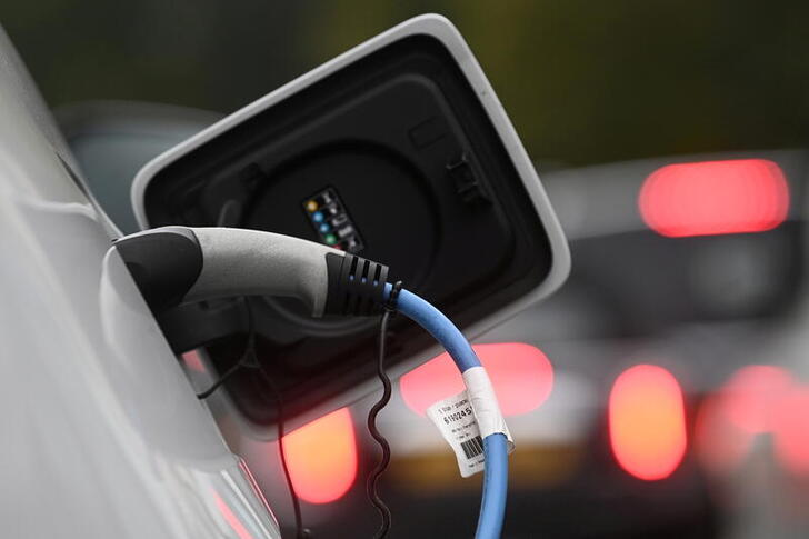 FILE PHOTO: An electric car is charged at a roadside EV charge point, London, October 19, 2021. REUTERS/Toby Melville/File Photo