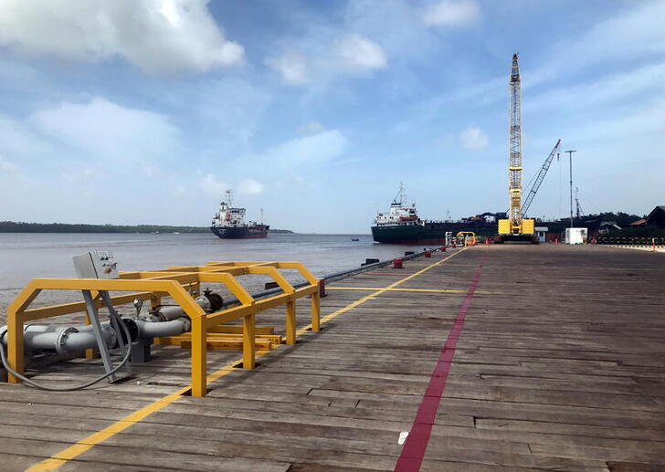 FILE PHOTO: Vessels carrying supplies for an offshore oil platform operated by Exxon Mobil are seen at the Guyana Shore Base Inc wharf on the Demerara River, south of Georgetown, Guyana January 23, 2020. REUTERS/Luc Cohen/File Photo