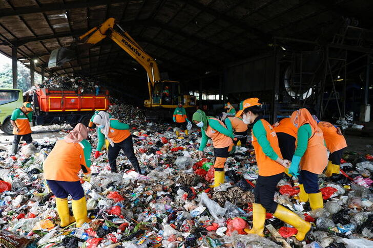 Workers short the trash at Bantar Gebang landfill in Bekasi, West Java province, Indonesia, August 12, 2021. Picture taken August 12, 2021. To match Special Report ENVIRONMENT-PLASTIC/CEMENT    REUTERS/Willy Kurniawan