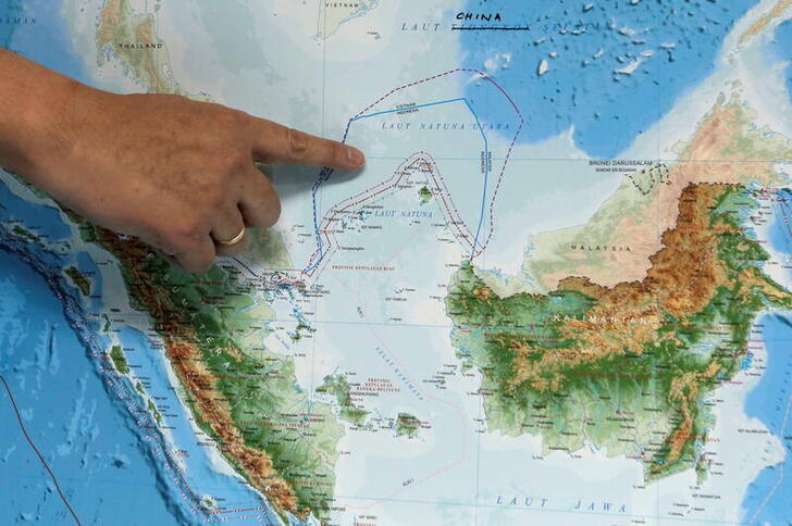 FILE PHOTO: Indonesia's Deputy Minister for Maritime Affairs Arif Havas Oegroseno points at the location of North Natuna Sea on a new map of Indonesia during talks with reporters in Jakarta, Indonesia, July 14, 2017.  REUTERS/Beawiharta/File Photo