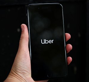 FILE PHOTO: Uber's logo is displayed on a mobile phone in London, Britain, September 14, 2018. REUTERS/Hannah Mckay/File Photo