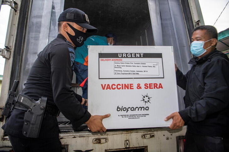 Officers offload a box of Sinovac's vaccine for coronavirus disease (COVID-19) as it arrives at the cold room of Indonesia's local health department in Palembang, South Sumatra province, Indonesia, January 4, 2021 in this photo taken by Antara Foto.  Antara Foto/Nova Wahyudi/ via REUTERS  ATTENTION EDITORS - THIS IMAGE WAS PROVIDED BY A THIRD PARTY. MANDATORY CREDIT. INDONESIA OUT.